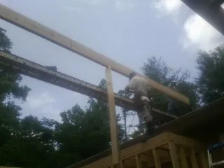 Carpenter setting a ridge beam over a new addition frame — Ice Dam Removal by Roofing Brothers in Micaville