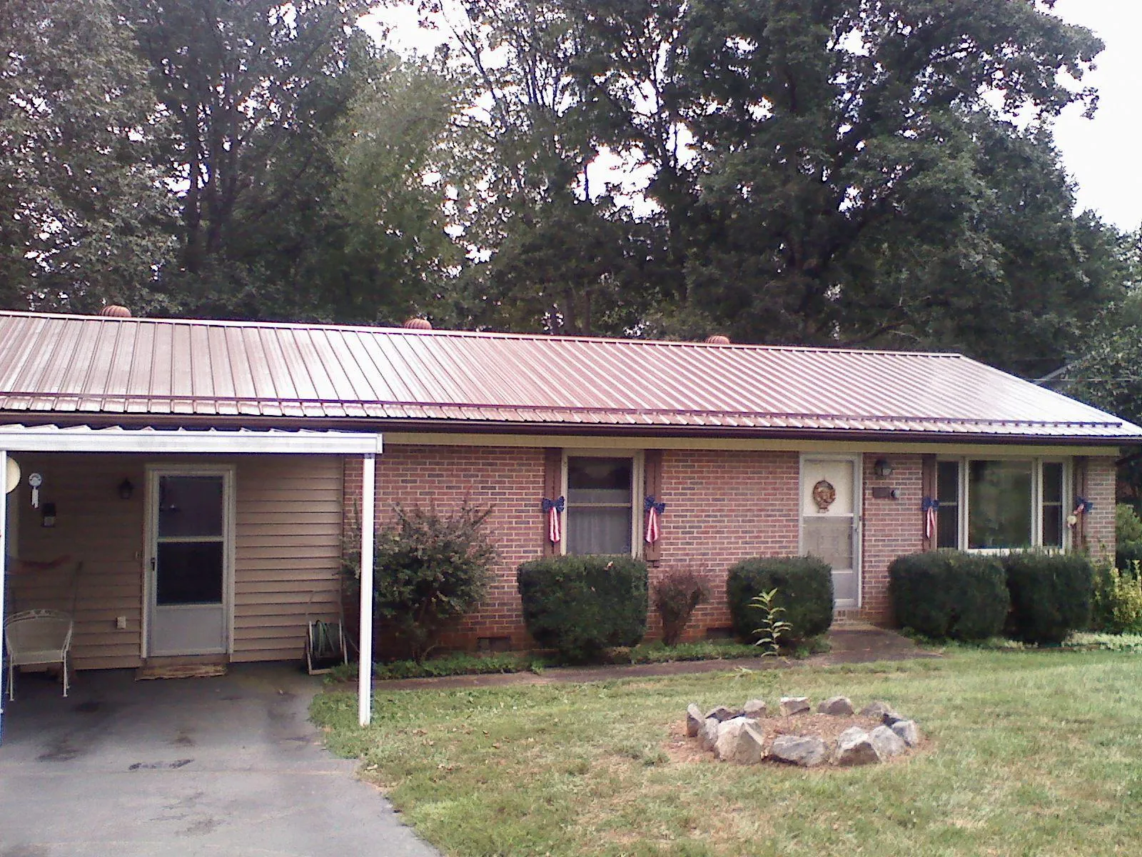 Bronze metal roof and carport on a brick ranch home — Roof Repair work by our crew in Micaville