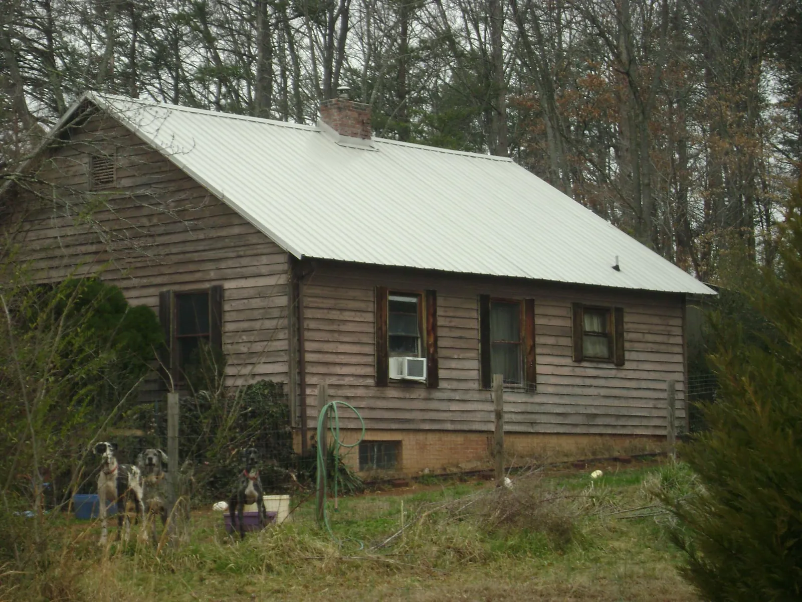 White metal roof on an old wood sided farmhouse, from a Metal Roof Installation job in Micaville